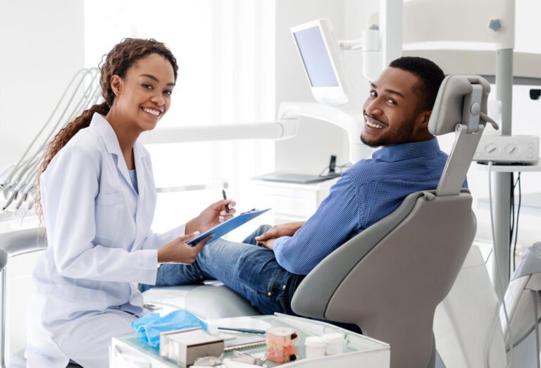 Smiling female dentist talking to patient, filling medical form