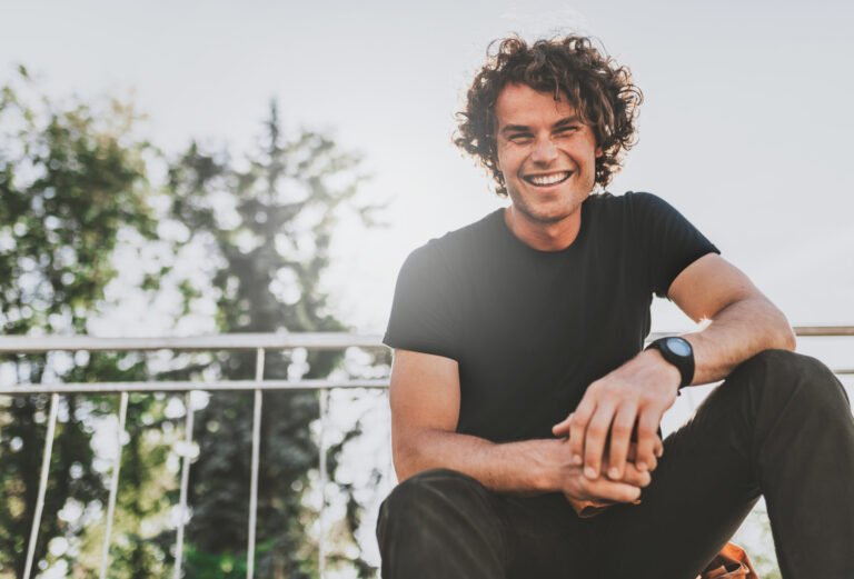 Low view shot of happy stylish young man wears black t-shirt and