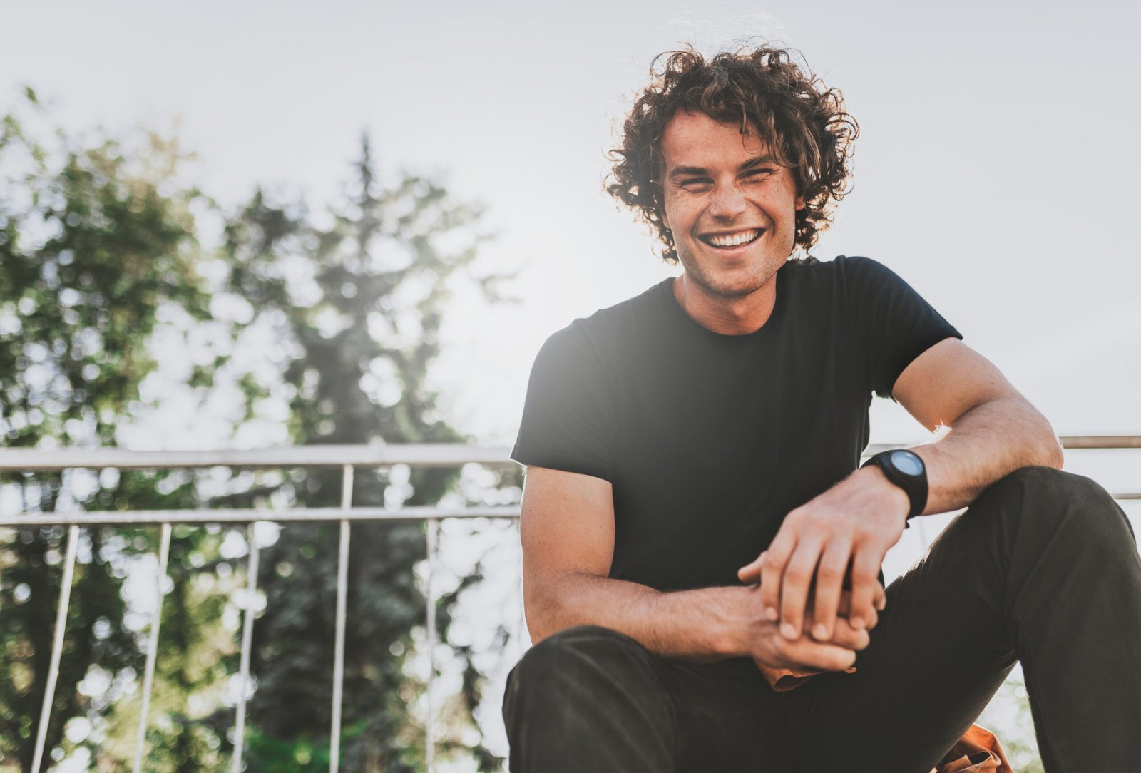 Low view shot of happy stylish young man wears black t-shirt and